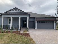 Two-story home with gray siding, brown roof, and a two-car garage at 4699 Southern Valley Loop, Brooksville, FL 34601