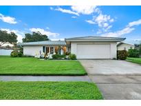 White single story home with a two car garage and well manicured lawn at 14542 Anchorage Cir, Seminole, FL 33776