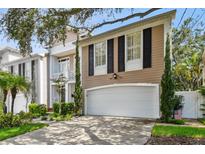 Charming home featuring a two-car garage, manicured lawn, and classic architectural details at 2527 W Maryland Ave # A, Tampa, FL 33629