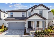 Two-story home with gray siding, gray roof, and a large gray garage door at 1692 Fallon Pass, Zephyrhills, FL 33541