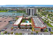 Aerial view of condo complex with pool, parking and marina at 10369 Paradise Blvd # 58, Treasure Island, FL 33706
