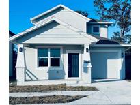 Two-story house with gray exterior, dark gray door, and attached garage at 2404 1/2 E Chelsea, Tampa, FL 33610