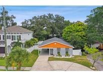 Charming house with gray and orange exterior, landscaped yard, and driveway at 4607 W San Jose St, Tampa, FL 33629