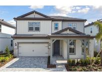 Two-story home with gray siding, stone accents, and a 2-car garage at 1686 Fallon Pass, Zephyrhills, FL 33541