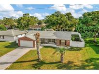 Charming single-story brick home with a well-manicured lawn and a two car garage at 13084 Drysdale St, Spring Hill, FL 34609