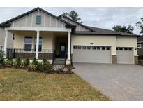 Two-story house with a three-car garage, front porch, and landscaped yard at 4638 Southern Valley Loop, Brooksville, FL 34601