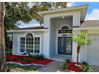 Two-story home with gray exterior, landscaped yard, and double-door entry at 2204 Cattleman Dr, Brandon, FL 33511