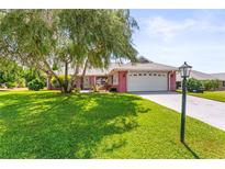 Brick ranch home with attached garage and lush lawn at 1804 New Bedford Dr, Sun City Center, FL 33573