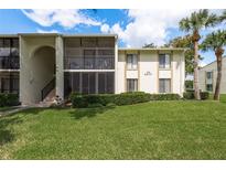 Exterior view of condo building with well-manicured lawn at 3133 Lake Pine Way # D1, Tarpon Springs, FL 34688