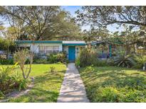 Ranch style home with teal accents, walkway, and mature landscaping at 509 Langford Cir, Plant City, FL 33563