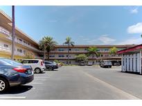 Exterior view of apartment building with spacious parking lot and lush landscaping at 5530 80Th St N # C203, St Petersburg, FL 33709