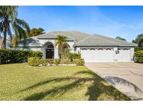 Single-story home with a three-car garage and manicured lawn at 8929 Cashella Ct, Trinity, FL 34655