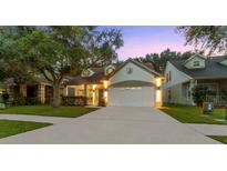 Two-story house with a white garage door and landscaped yard at 2944 Prairie Iris Dr, Land O Lakes, FL 34638