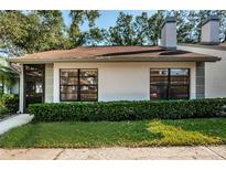 White exterior house with green landscaping and a brown roof at 3508 Magnolia Ridge Cir # 301, Palm Harbor, FL 34684