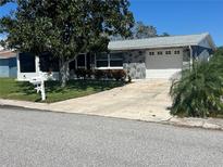 Charming single-story home boasts an inviting front yard and attached two-car garage at 4041 Star Island Dr, Holiday, FL 34691