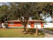 Brick ranch house with attached garage and mature landscaping at 468 Limewood Ave, Dunedin, FL 34698