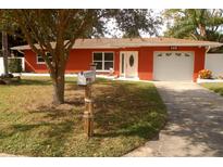 Brick ranch house with attached garage and well-maintained lawn at 468 Limewood Ave, Dunedin, FL 34698