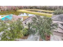 Aerial view of house and surrounding landscape, including a pond at 10918 Ancient Futures Dr, Tampa, FL 33647