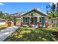 Charming craftsman style home with a covered porch and landscaped lawn at 1518 E Knollwood St, Tampa, FL 33610