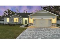 Charming house exterior featuring a two-car garage and stone accents at 37570 Teri Ct, Dade City, FL 33525