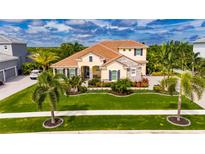 Beautiful two-story house with a landscaped yard and palm trees at 824 Manns Harbor Dr, Apollo Beach, FL 33572