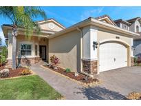 Tan one-story house with a two-car garage and landscaped walkway at 2632 Tarragona Way, Wesley Chapel, FL 33543