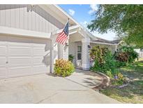 House exterior featuring a garage, walkway, and nicely landscaped yard at 1300 Cedar Ct, Tarpon Springs, FL 34689