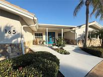 Inviting home exterior featuring a covered entryway and lush landscaping at 165 4Th N Ave, Tierra Verde, FL 33715