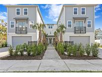 Front view of two-story townhouses with gray siding, attached garages, and landscaped yards at 208 W Frances Ave # 3, Tampa, FL 33602