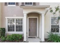 Tan two-story townhome with a brown door and landscaping at 4517 Kennewick Pl, Riverview, FL 33578