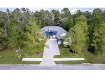 Aerial view of a house with a large driveway and mature trees at 4586 Hickory Oak Dr, Brooksville, FL 34601