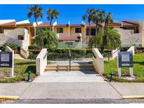 Beautiful condo complex with landscaped entrance, stairs, palm trees and building number 7520 at 7520 Sunshine Skyway S Ln # 210, St Petersburg, FL 33711