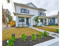 Two-story duplex with modern design, landscaping, and paved walkways at 1906 Cherry W St # 1, Tampa, FL 33607