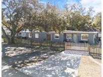 Gray house with wooden fence and driveway, surrounded by large trees at 2820 W Leila Ave, Tampa, FL 33611