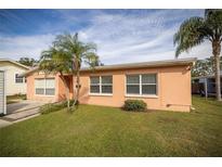 Ranch-style home with a well-manicured lawn and palm trees at 809 41St N Ave, St Petersburg, FL 33703