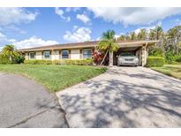 Charming single-story home with a well-manicured lawn, a carport, and beautiful landscaping at 2104 Hembury Pl # 33, Sun City Center, FL 33573