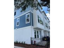 Charming townhome features a blue and white exterior and black metal fence at 6605 N Nebraska Ave # 22, Tampa, FL 33604