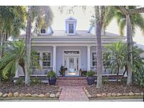 Light blue house with white columns, brick walkway, and lush landscaping at 618 Islebay Dr, Apollo Beach, FL 33572