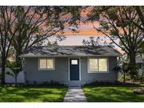 Charming gray house with a blue door, well-manicured lawn, and a welcoming walkway at 6338 8Th S Ave, Gulfport, FL 33707