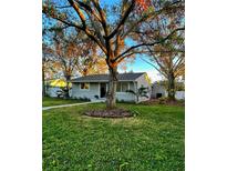 Newly renovated home with a well-manicured lawn and mature trees at 6338 8Th S Ave, Gulfport, FL 33707