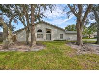 Single-story house with a light-colored exterior, visible landscaping, and a two-car garage at 2966 Brookfield Ln, Clearwater, FL 33761