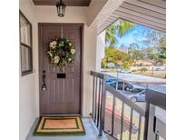 Inviting condo entry with wreath and view of lush landscaping at 3505 Tarpon Woods Blvd # K409, Palm Harbor, FL 34685