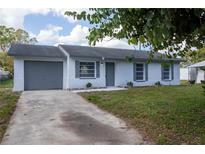 Newly painted one-story home with gray shutters and a gray garage door at 5341 Tangerine Dr, Zephyrhills, FL 33542