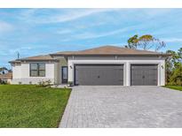 Attractive one-story home with a three-car garage and a paved driveway at 12140 Warden Ave, Port Charlotte, FL 33981