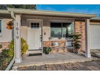 Inviting front porch with seating and potted plants at 1619 Coppertree Dr, Tarpon Springs, FL 34689