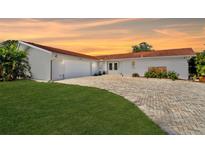 White single-story house with a red tile roof, two-car garage, and landscaped lawn at 853 Seacrest Dr, Largo, FL 33771