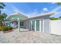 Charming home featuring a covered porch, large windows, and a paved driveway at 453 85Th Ave, St Pete Beach, FL 33706