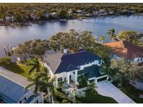 Stunning waterfront home with a metal roof, lush landscaping, and a private boat dock along a serene waterway at 1100 Monterey Ne Blvd, St Petersburg, FL 33704
