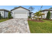 House exterior featuring a two-car garage and well-manicured lawn at 9430 Shorebird Ct, Parrish, FL 34219