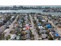 Aerial view of coastal neighborhood with waterfront access; homes with pools, canals, and bay views at 422 86Th Ave, St Pete Beach, FL 33706